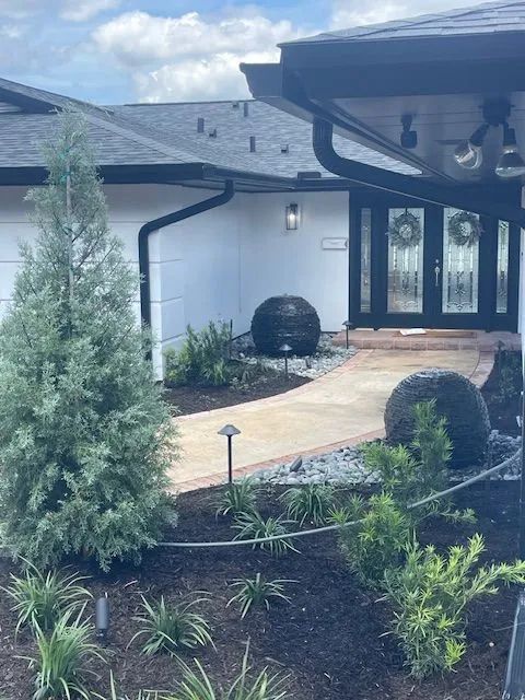 Solid drain pipe routed through trench along landscaped bed in Central Florida